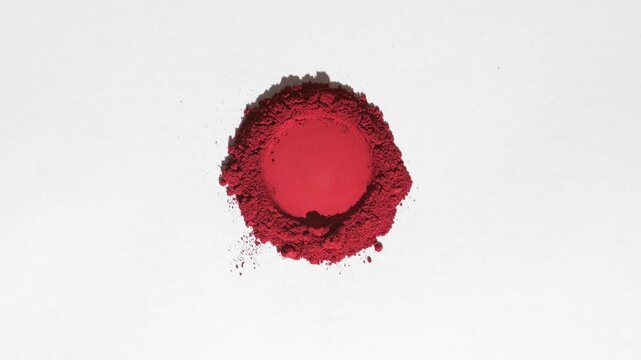 Overhead shot of a heap of red powder marked with a round shape on a muted grey background illuminated by orbiting directional light that casts dynamic shadow | Blush ad campaign idea