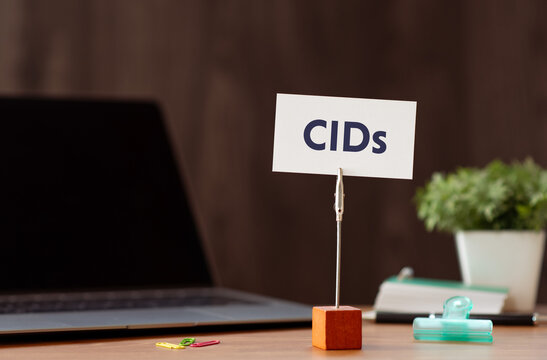 Eye-catching image of CIDs text on card. The word stands for Climatic impact-drivers. Shown with laptop, clips.