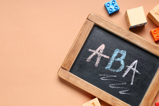Applied behavior analysis (ABA) therapy concept on chalkboard with building blocks for autism spectrum disorder treatment