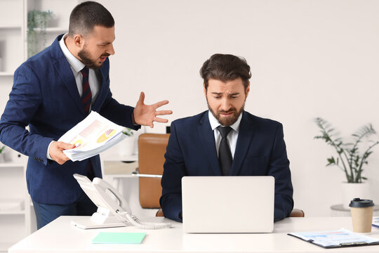 Angry boss yelling at stressed employee in office, workplace conflict and business pressure