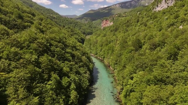 Cinematic Landscape Reveal of Tara River Canyon and Bridge in Montenegro, Smooth Backward Drone Tracking Shot with Mountain Cliffs and Sky, Aerial 4K Video