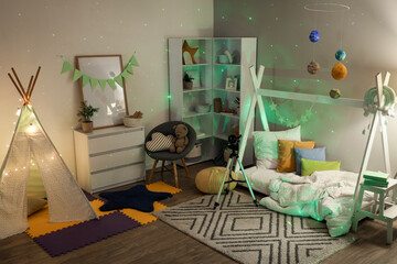 Cozy children's bedroom with star projector, teepee tent, and planet mobile for imaginative play and learning © Pixel-Shot