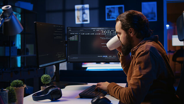 Stressed engineer feeling pressed by deadline, thinking how to finish developing code on PC. IT specialist brainstorming ways of solving database errors, working hard, drinking coffee.