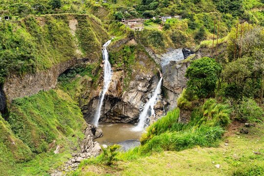 Waterfalls Cascade Down Rocky Cliffs in Baos, Tungurahua, Ecuador, Surrounded by Green Hills and Vegetation
