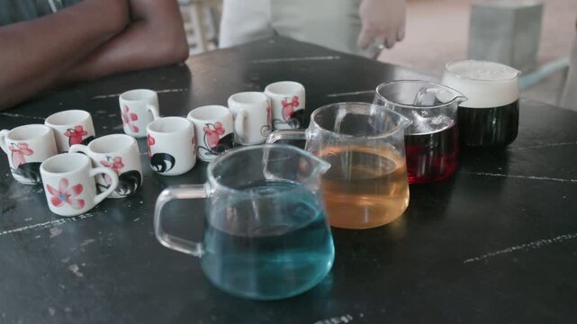 A tea tasting ceremony with various colorful teas in glass pots and small cups, at a cafe in Mae Klang Luang, Chiang Mai, Thailand