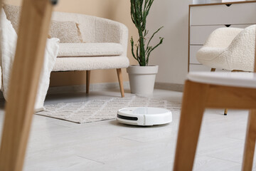 Fototapeta premium Modern robot vacuum cleaner on floor at home