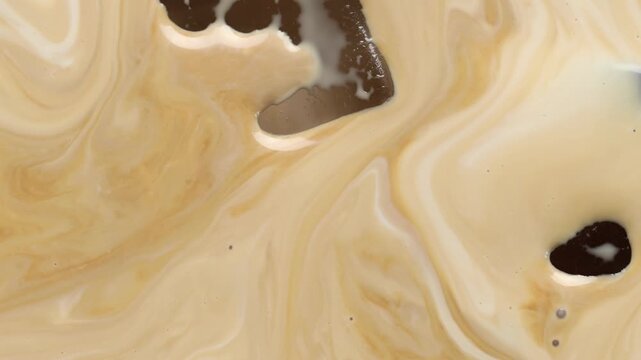 Delicious coffee with milk and ice cubes as background, top view