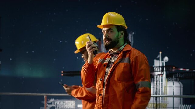 Drilling rig worker doing radio coordination during global energy embargo while offshore platform engineer communicating alerts under aurora borealis sky to mitigate oil crisis disruptions.