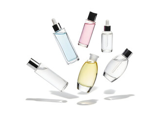 Obraz premium Assortment of luxury cosmetic bottles with dropper applicators on white background