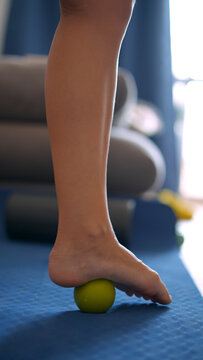 Bare foot balancing on massage ball during exercise
