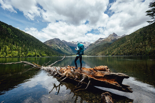 Hiking woman on a one plank bridge in high altitude mountains