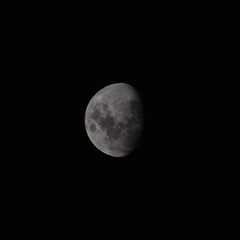 Obraz premium Close up of a three quarter moon in front of a black sky
