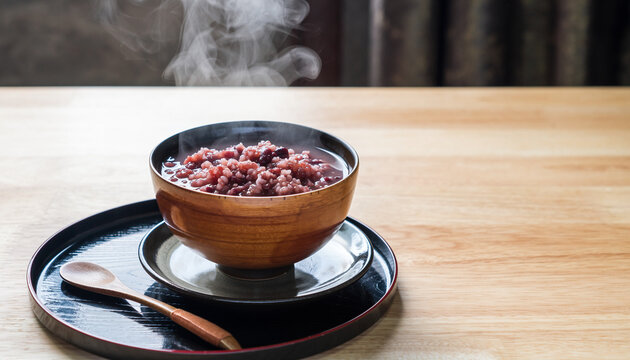 湯気が立ち上る温かい小豆粥と木製スプーンの和食セット