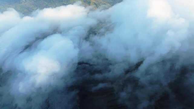 Revealing ijen volcano crater lake through moving clouds