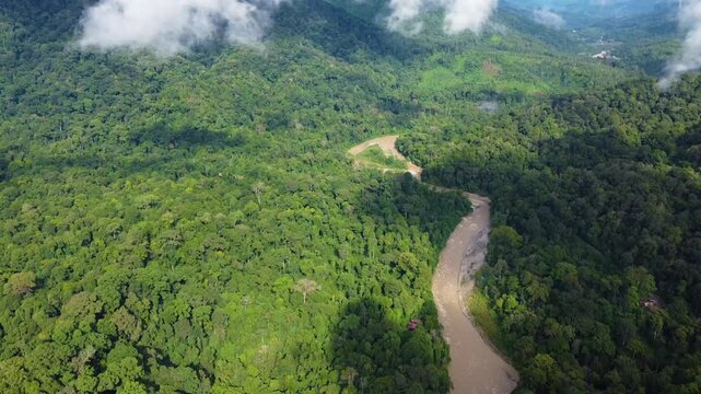 Drone flying above a tropical rainforest and river in sumatra