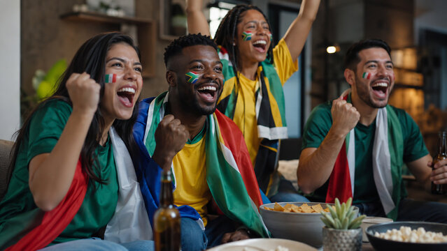 Mexican and South African fans celebrating football match indoors