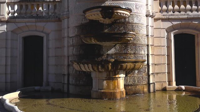Ornate rococo stone fountain with cascading water in the gardens of the Queluz National Palace, a famous historical landmark and popular tourist destination near Lisbon, Portugal on a sunny day