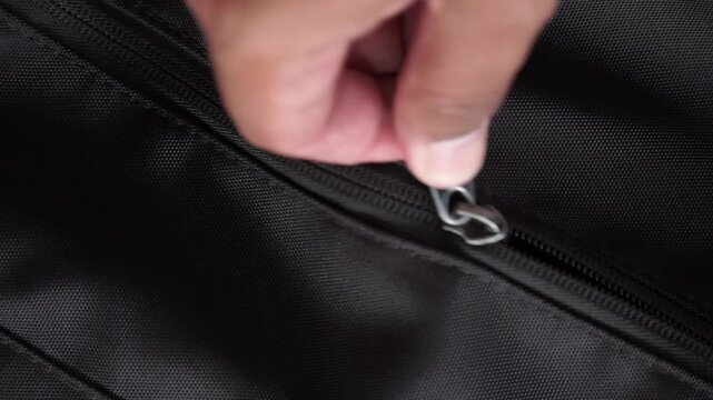 Hand retrieving a bottle of hand sanitizer from a zippered bag in close-up view, ideal for technology, travel, and lifestyle concepts.