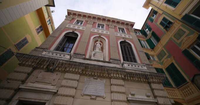 Historic building facade featuring a statue surrounded by vibrant, traditional Italian architecture
