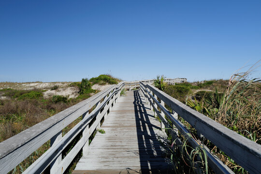 Wooden boardwalk crossing over sand dunes onto St. Augustine Beach in Florida during Winter