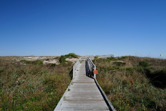 Wooden boardwalk crossing over sand dunes onto St. Augustine Beach in Florida during Winter