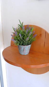 Potted Artificial Lavender Plant Placed on a Rustic Half-Round Wooden Wall Mounted Shelf for Interior Home Decor