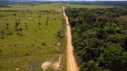 AMAZONAS, BRAZIL - JUNE 8, 2026: Drone perspective of a remote unpaved road cutting through a vast landscape of smallholder pastures and native Amazon vegetation. © rafael