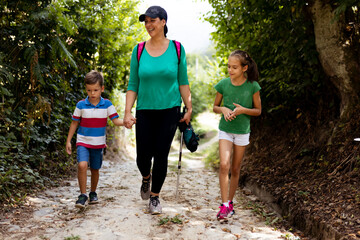 Naklejka premium Family Enjoying a Scenic Walk on a Nature Trail During a Sunny Day