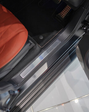 Open Car Door Edge And Orange Seat Interior View.
