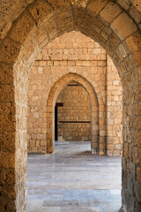 Naklejka premium Perspective through the stone arches inside the historic Bab Makkah gate in Jeddah, Saudi Arabia