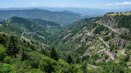 Fototapeta premium Scenic Mountain View Overlooking Lush Green Valley With Winding Road and Clear Blue Skies in Vibrant Daylight
