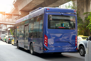 A blue passenger bus is stuck in a traffic jam among other vehicles on a route in a metropolis. © aapsky