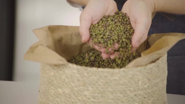 Granos secos variados, legumbres y alimentos naturales para alimentaci&oacute;n saludable, mano sosteniendo y dejando caer granos en c&aacute;mara lenta (Slow Motion), Footage cocina, comida