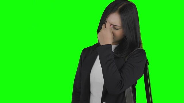 Stressed Asian Businesswoman Suffering from Severe Headache on Green Screen