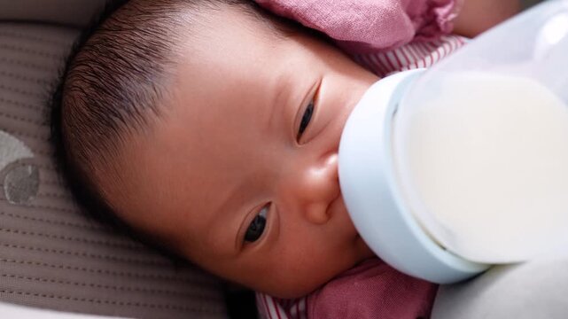 Close Up of Newborn Baby Drinking Milk from a Bottle