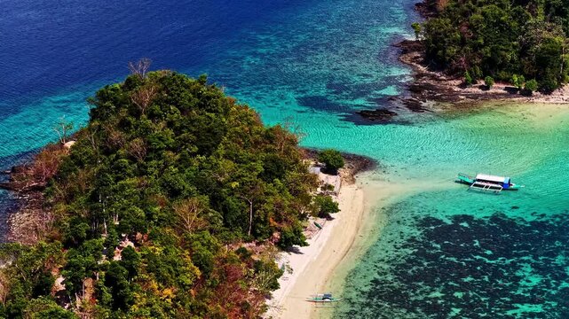 Tropical island beach with turquoise water and boat in Port Barton, Philippines