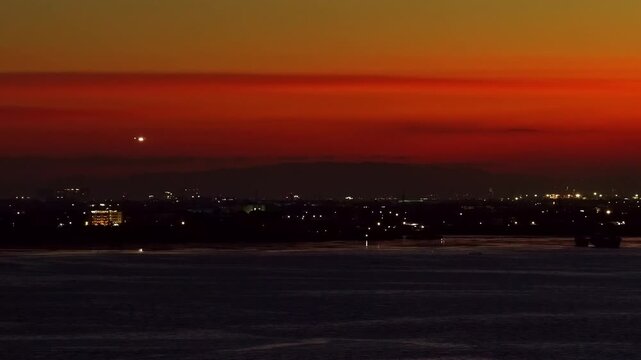 Mactan Island skyline during a beautiful red-orange sunset in aerial view with plane landing
