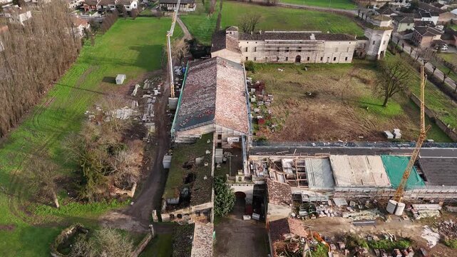 Corte di Casatico in Casatico, Marcaria, Mantova, Lombardy, Italy, showing historic rural courtyards, restoration activity and traditional agricultural architecture, drone ascent reveal shot.