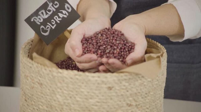 Poroto colorado seco, legumbre para alimentaci&oacute;n saludable y prote&iacute;na vegetal, mano sosteniendo y dejando caer granos en c&aacute;mara lenta (Slow Motion), Footage cocina, comida