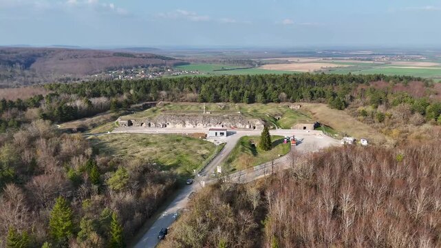 Drone view of Fort de Vaux earthworks, concrete entrances, forest, and farmland near Verdun in Meuse, Grand Est, France.