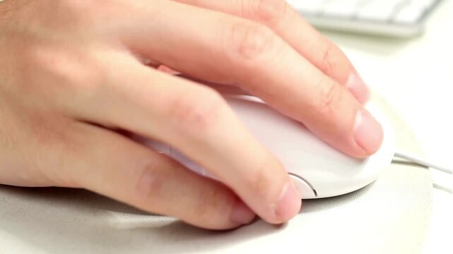 hand click white computer mouse on bright desk setup for internet technology and digital office business workspace