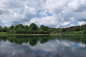 Obraz premium Amazing scenery of kashubian landscape with Grabowko lake and clouds on blue sky in summer day. Kashubia, Pomerania, Poland