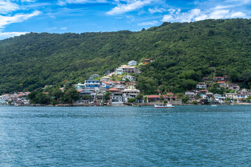 Obraz premium Coastal village on a lush green hill by the sea in Brazil