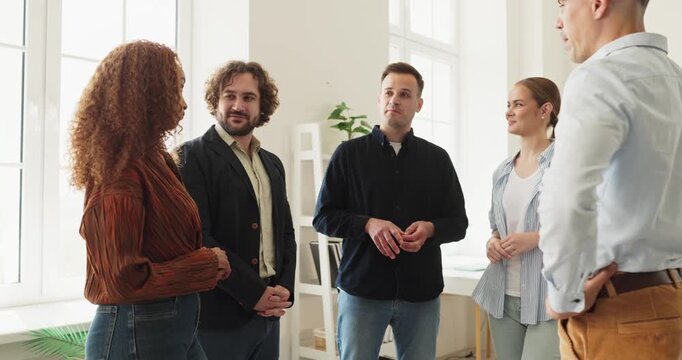 Friends group of adults talking at home. Casual conversation during a small social gathering. Smiling people listen with open gestures and trust. Strong concept of clear open communication.
