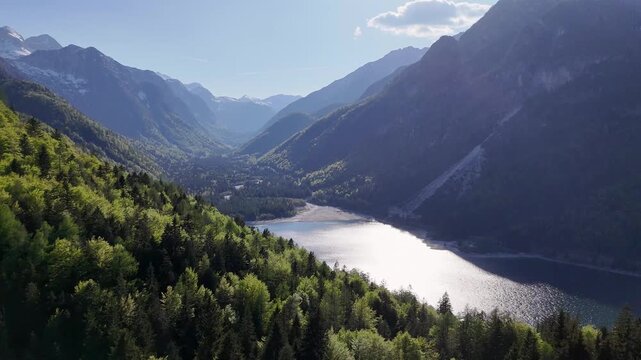 Aerial view of a forested alpine valley with a turquoise river in Triglav National Park, Slovenia.