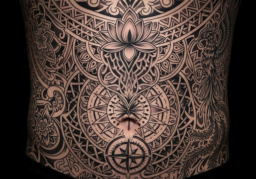 Intricate blackwork tattoo covering a person's torso, featuring a central lotus flower, geometric patterns, and a compass rose design.