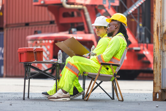 Warehouse managers working at shipping yard, Industrial site supervisors checking logistics data with clipboard outdoors, Logistics professionals reviewing documents at container terminal