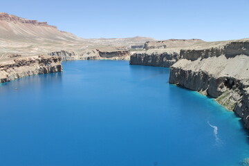 Fototapeta premium Band-e Amir National Park showcases Afghanistan’s breathtaking natural beauty with crystal-clear turquoise lakes, dramatic cliffs, and peaceful landscapes under a vibrant blue sky.