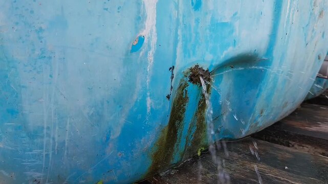 Selective focus. Water leakage from crack in water tank installed in house rooftop. Leak plastic water tanks.
