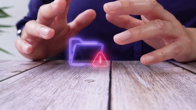 Security alert in digital folders. Close-up of a pair of hands on a table, shielding a virtual folder icon and a warning sign.